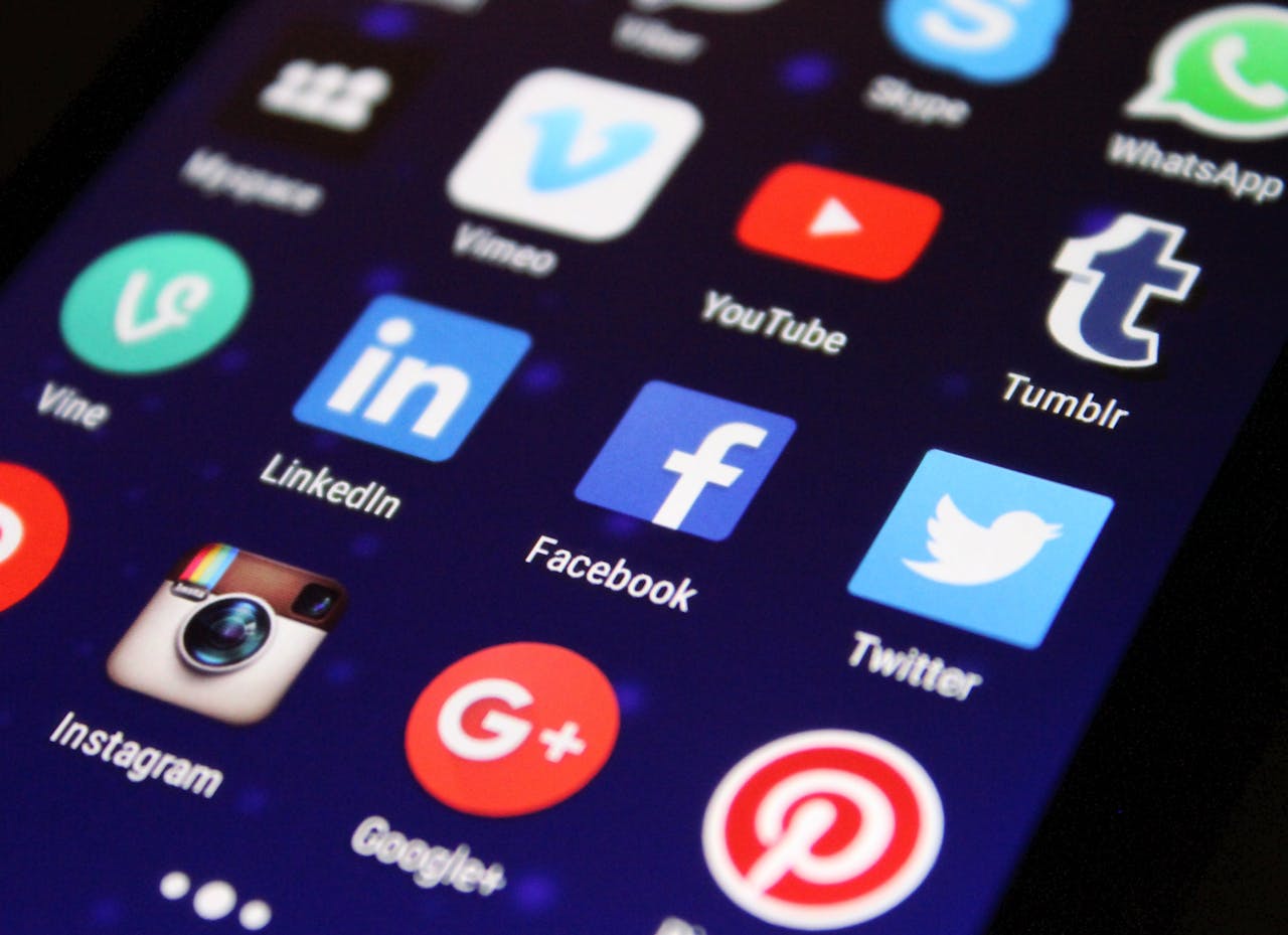 services-01 Close-up of a smartphone screen showing various social media app icons such as Facebook and Twitter.