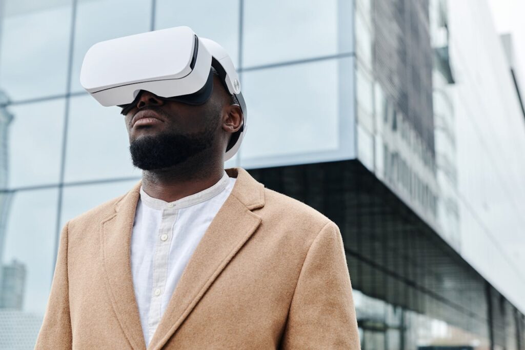 A man wearing VR glasses and a coat, engaging with virtual reality technology outdoors.